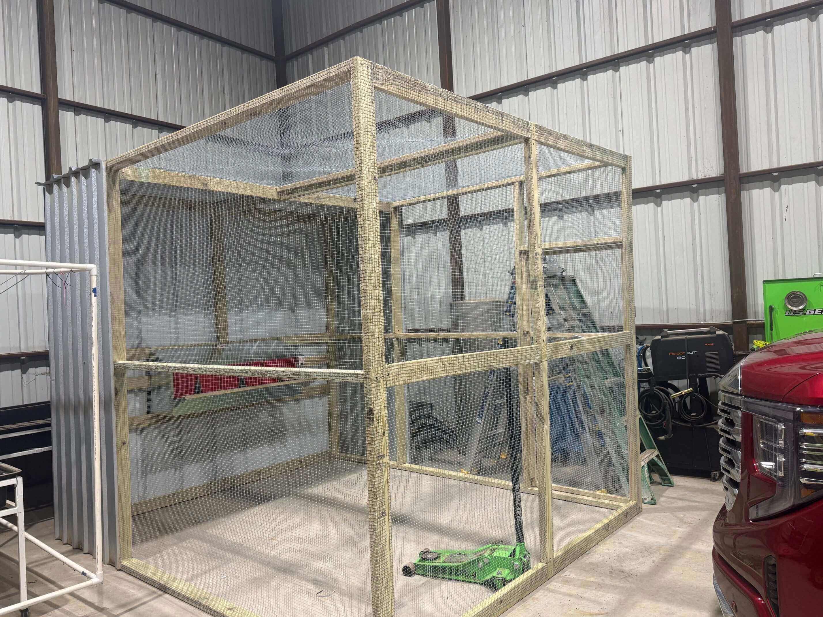 Wooden framed wire mesh enclosure inside garage
