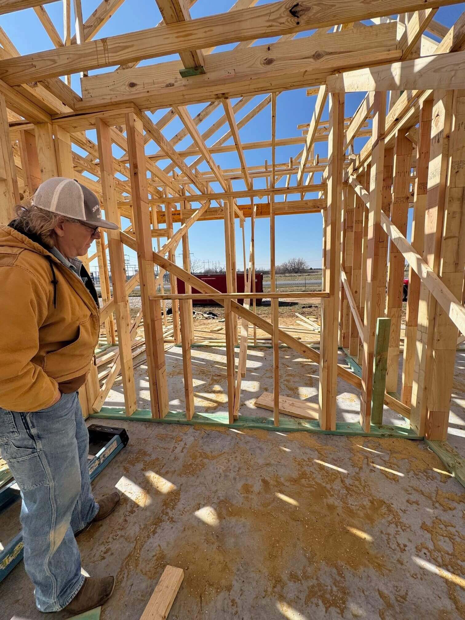 Person inspecting wooden house framing
