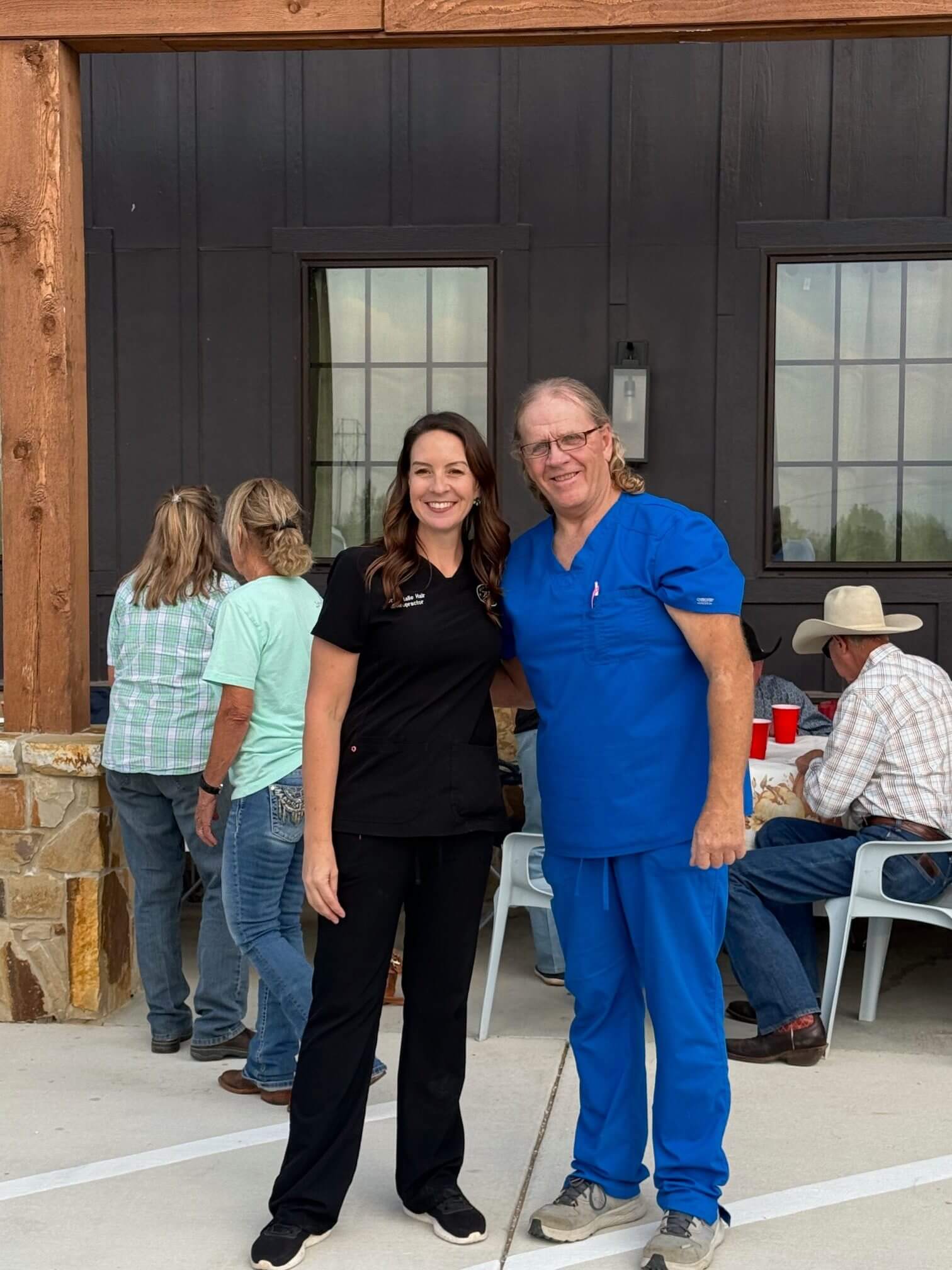 Two smiling healthcare workers posing outdoors